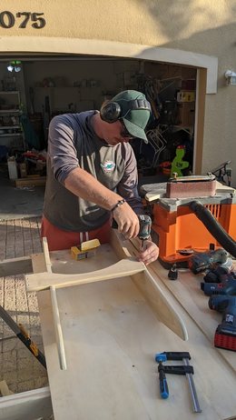 Andreas screwing together an Adirondack chair frame in the driveway