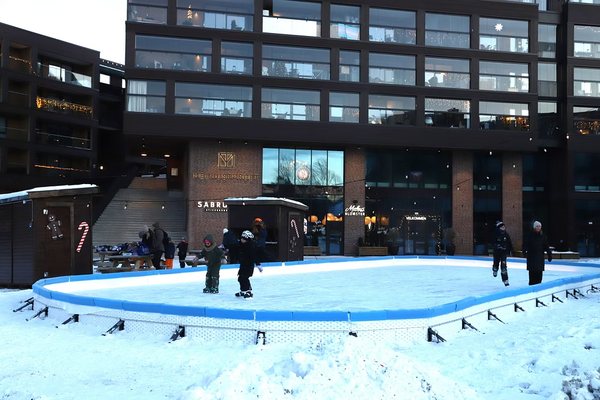 Kids skating on the rink outside Melhustorget at dusk