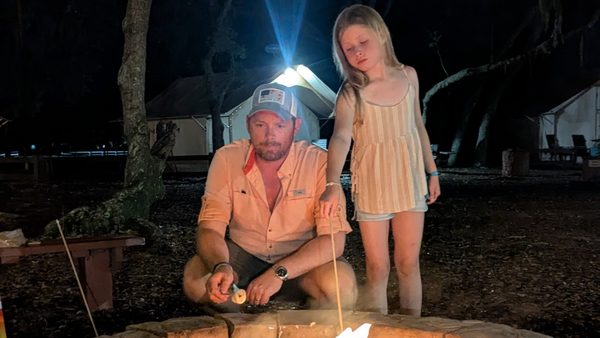 Andreas and Olivia roasting marshmallows over a campfire at night