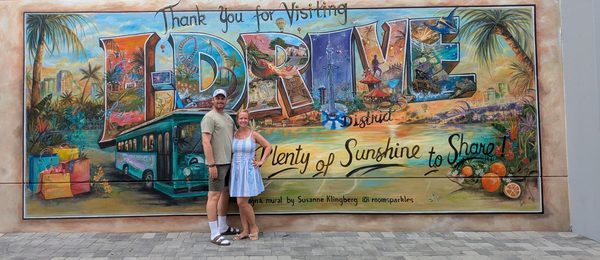 Andreas and Rachel in front of a painted I-Drive postcard mural